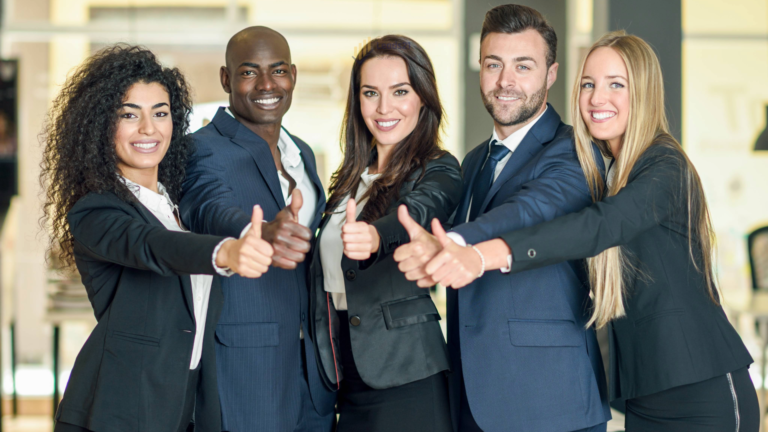 Group of businesspeople with thumbs up gesture in modern office. - leads21